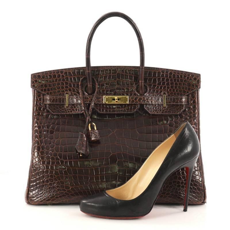 This authentic Hermes Birkin Handbag Havane Shiny Porosus Crocodile with Gold Hardware 35 stands as one of the most-coveted bags fit for any fashionista. Constructed from genuine Havane Shiny Porosus crocodile, this stand-out oversized tote features