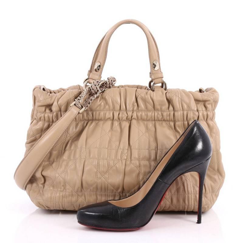 This authentic Christian Dior Delices Tote Cannage Quilt Leather Medium is a classic staple that every fashionista needs in her wardrobe. Crafted from beige leather, this tote features a ruched silhouette with Dior's signature cannage stitching,