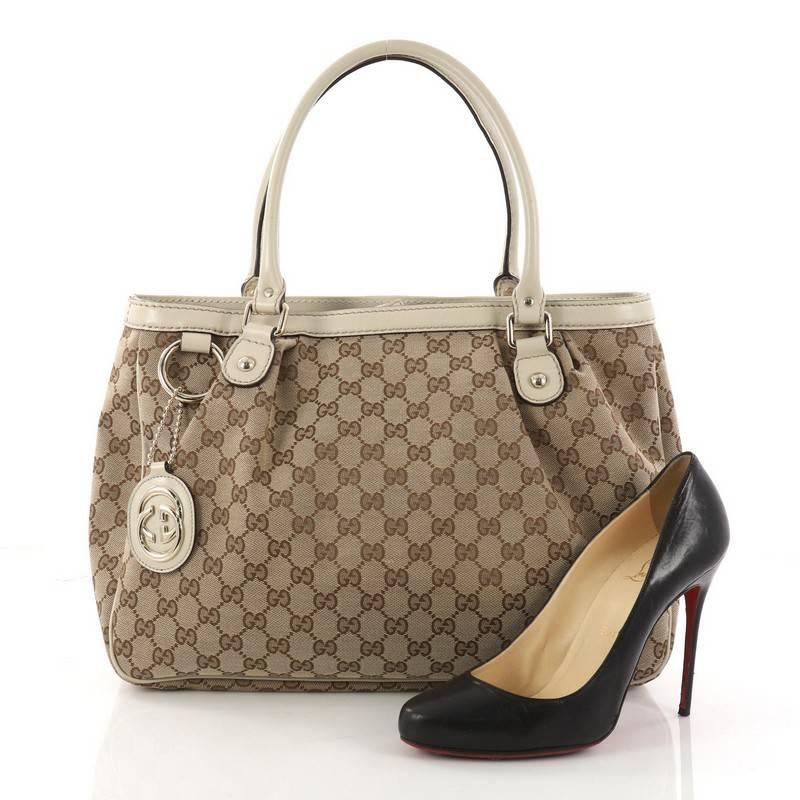 This authentic Gucci Sukey Top Handle Tote GG Canvas Medium is a chic tote ideal for everyday wear. Crafted from Gucci's light brown GG canvas with leather trims, this roomy tote features a ruched design, dual-rolled handles and gold-tone hardware