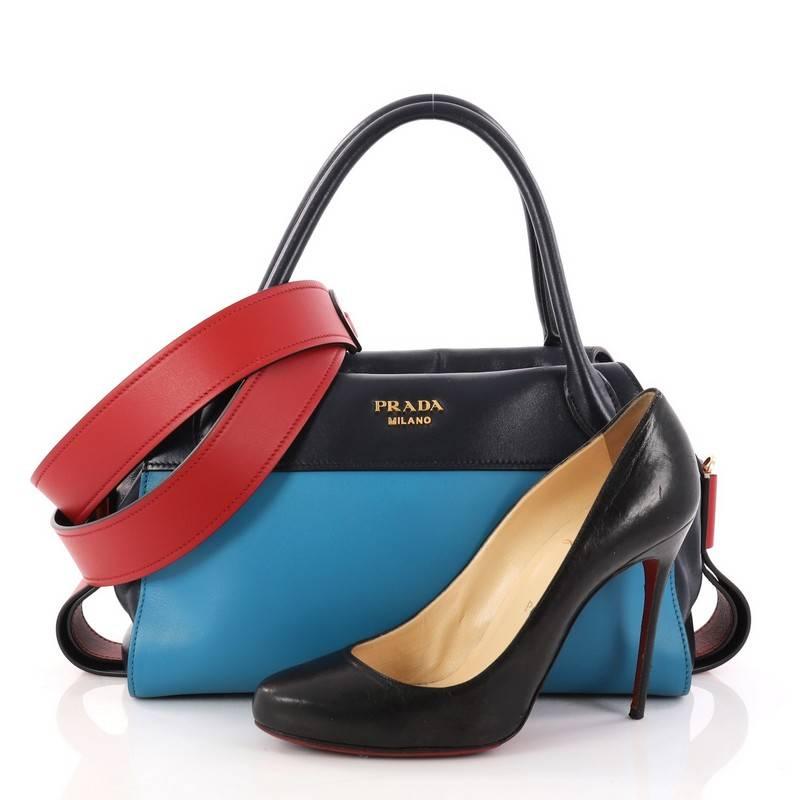 This authentic Prada Bowling Ribbon Bag City Calf is fashionably chic with an edgy stylish twist. Crafted in blue calf leather with red leather trims, this bowling bag features dual-rolled leather handles, Prada logo and gold-tone hardware accents.