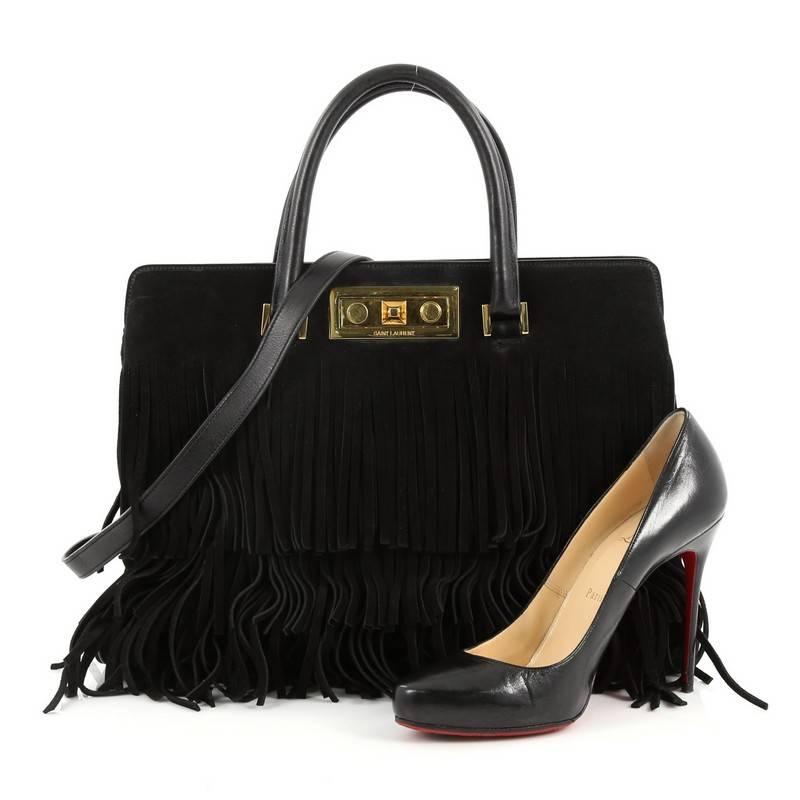 This authentic Saint Laurent Fringe Trois Clous Convertible Tote Suede Medium is a gorgeous bag perfect for your everyday looks. Crafted in black suede, this stylish bag features dual-rolled leather handles, detachable shoulder strap, push-lock