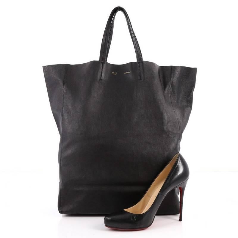 This authentic Celine Vertical Cabas Tote Leather Large is a perfect everyday accessory for the woman on-the-go. Crafted in black leather, this minimalist bag features slim handles and gold stamped brand name. Its wide top opening showcases a roomy