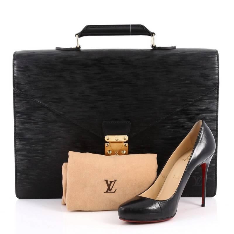 This authentic Louis Vuitton Serviette Ambassadeur Handbag Epi Leather is a classic yet functional briefcase made for work or daily excursions. Crafted with sturdy black epi leather, this structured briefcase features a classic envelope shape with