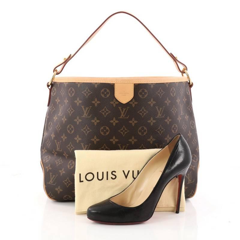 This authentic Louis Vuitton Delightful Handbag Monogram Canvas PM is a versatile hobo that can be used everyday. Constructed from the brand's classic brown monogram coated canvas with cowhide leather trims, this chic bag features a flat leather