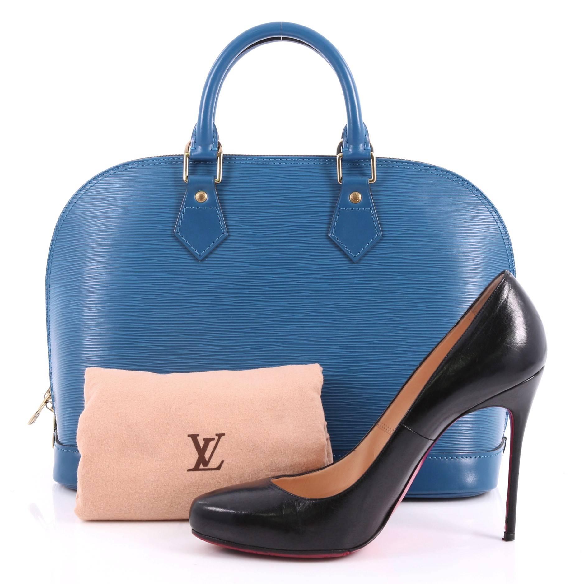 This authentic Louis Vuitton Vintage Alma Handbag Epi Leather PM is elegant and classic. Constructed with Louis Vuitton's signature blue epi leather, this iconic bag features dual rolled handles, a sturdy reinforced base, standout contrast