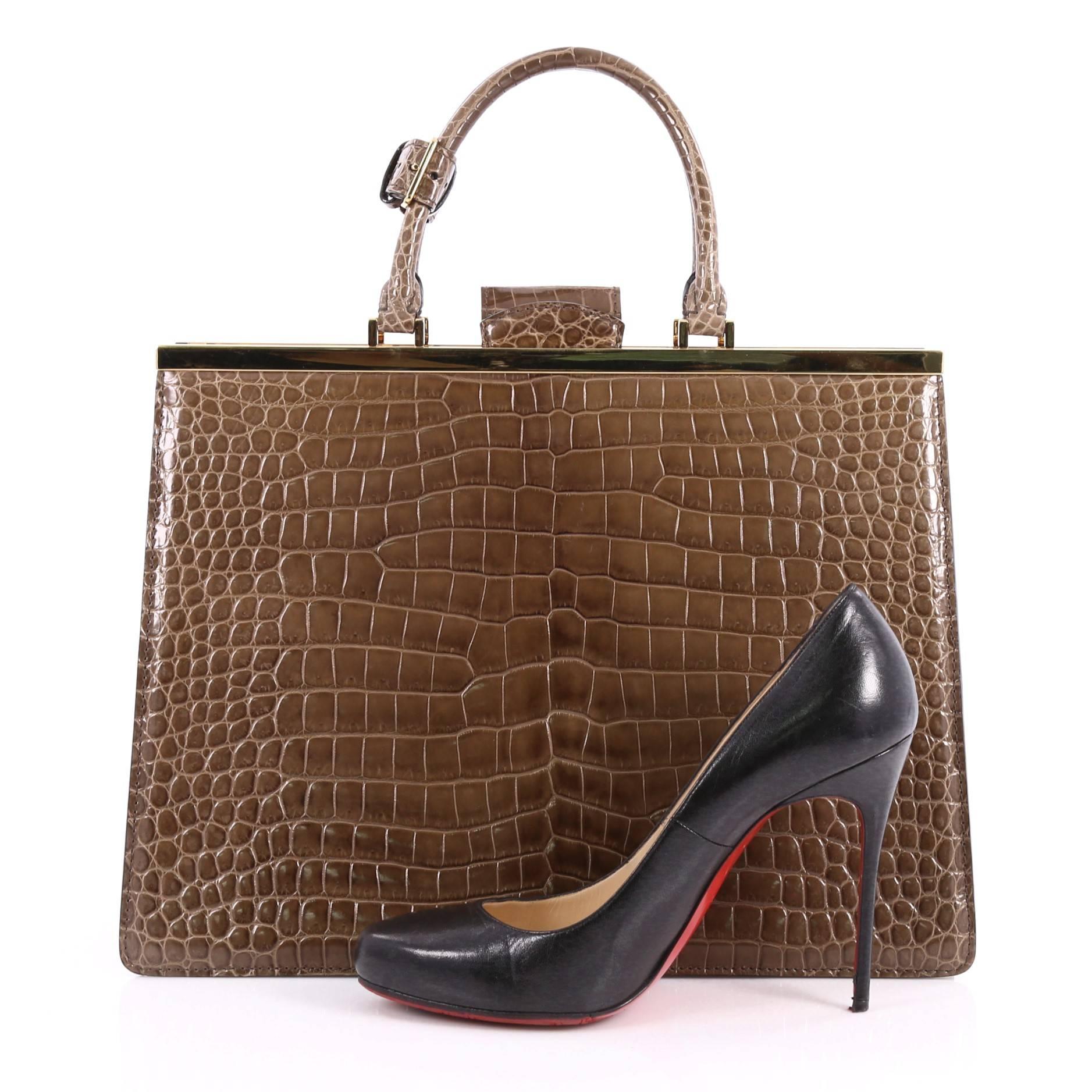 This authentic Louis Vuitton Deesse Handbag Crocodile MM inspired by 1950s retro-feminine glam is a luxurious tote for day or nights out. Crafted from genuine rustic brown crocodile, this sophisticated bag features dual-rolled top handles, lady-like