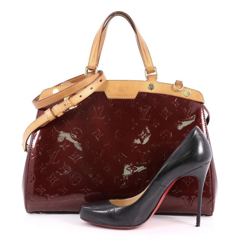 This authentic Louis Vuitton Brea Handbag Monogram Vernis MM is a staple for an everyday casual look. Crafted in pomme d'amour monogram vernis leather with cowhide leather trims, this structured yet feminine tote features dual flat handles,