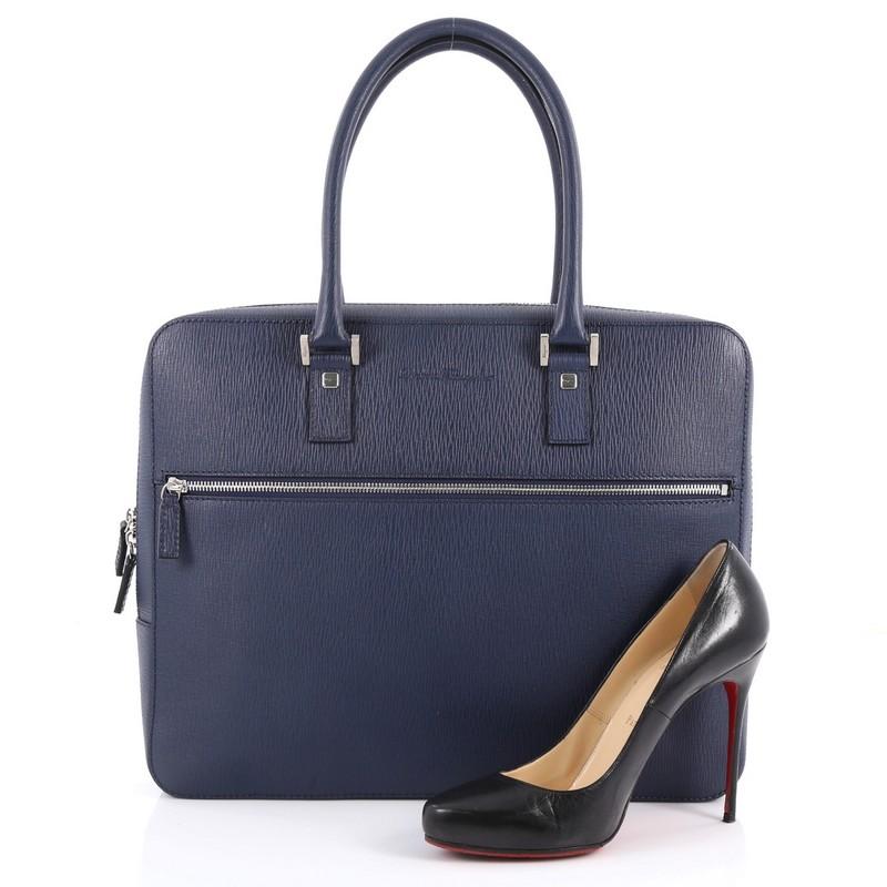 This authentic Salvatore Ferragamo Zip Around Briefcase Leather Medium is a stylish bag to carry all day long. Crafted in blue leather, this bag features dual-rolled leather, zip around closure, exterior zip pockets at front, and silver-tone