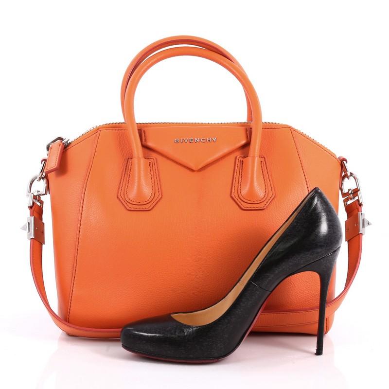 This authentic Givenchy Antigona Bag Leather Small combines style and functionality all-in-one. Crafted from orange leather, this structured handle bag is designed with dual-rolled leather handles and silver-tone hardware accents. The bag's zip