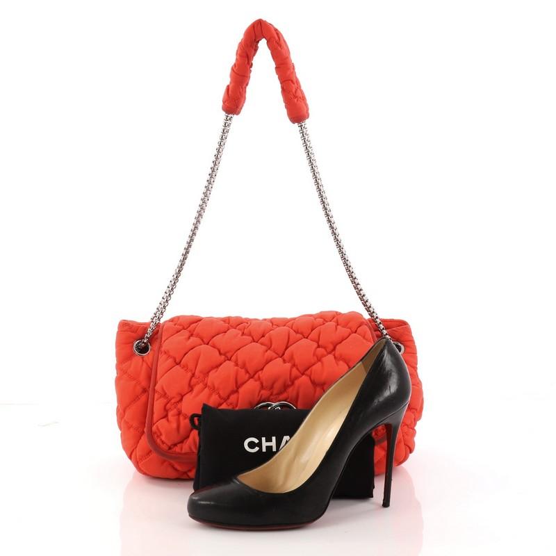 This authentic Chanel Bubble Accordion Flap Bag Quilted Nylon Medium is sure to complement every outfit. Crafted in red orange bubble quilted leather, this soft, puffy flap bag features woven-in leather chain strap threaded through eyelets cinching