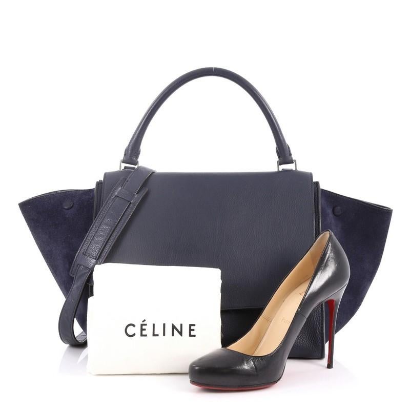 This authentic Celine Trapeze Handbag Leather Medium is a modern minimalist design with a playful twist in an array of subdued colors. Crafted from blue leather with blue suede wings, this popular bag features exterior back zip pocket, side snap