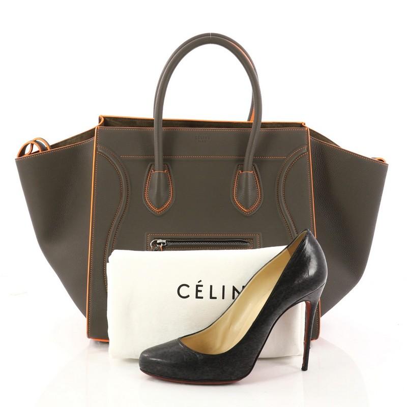 This authentic Celine Phantom Handbag Grainy Leather Medium is one of the most sought-after bags beloved by fashionistas. Crafted from olive green grainy leather, this minimalist tote features dual-rolled handles, an exterior front pocket,