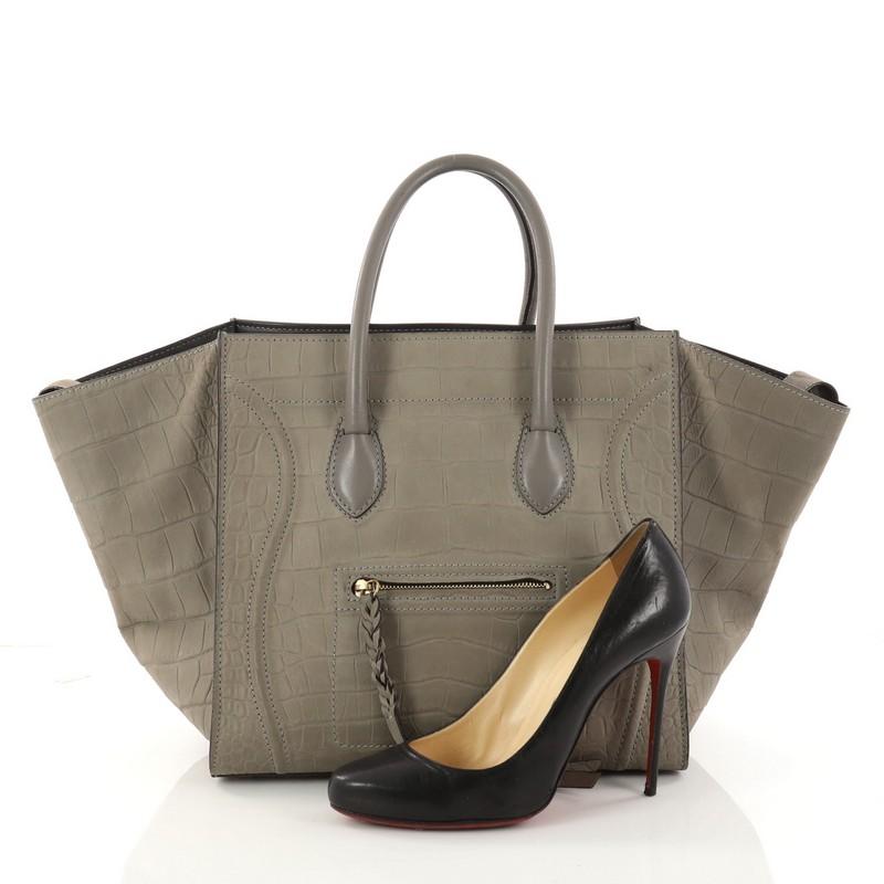 This authentic Celine Phantom Handbag Crocodile Embossed Nubuck Medium is one of the most sought-after bags beloved by fashionistas. Crafted from grey crocodile-embossed nubuck, this minimalist tote features dual-rolled handles, an exterior front