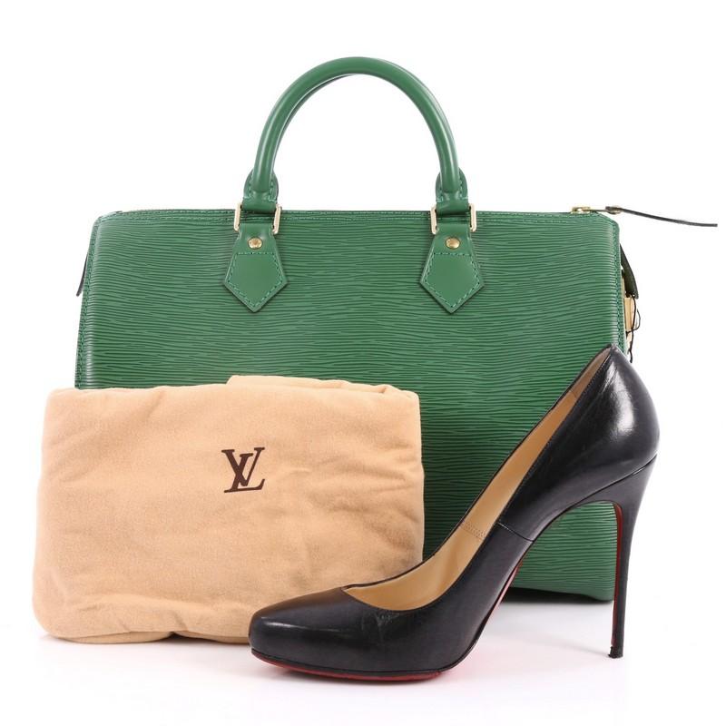 This authentic Louis Vuitton Speedy Handbag Epi Leather 30 is a fresh twist on the classic Louis Vuitton speedy design. Crafted from green epi leather, this rounded bag features dual-rolled leather handles, subtle LV logo, exterior side pocket and