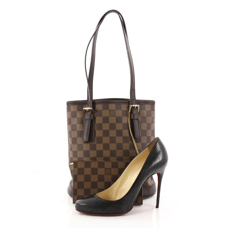 This authentic Louis Vuitton Marais Bucket Bag Damier showcases a simple and chic design making it an ideal accessory for all seasons. Crafted from the brand's signature damier ebene coated canvas, this bucket bag features dual tall leather handles