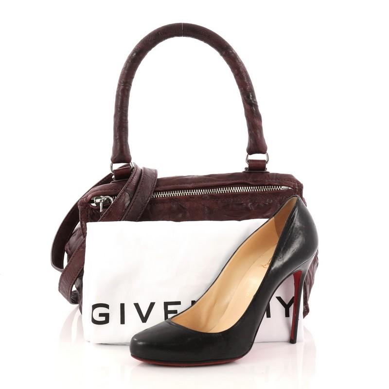 This authentic Givenchy Pandora Bag Distressed Leather Small is the perfect companion for any on-the-go fashionista. Crafted from burgundy distressed leather, this cult-favorite satchel features a pandora box-inspired silhouette, a singular top