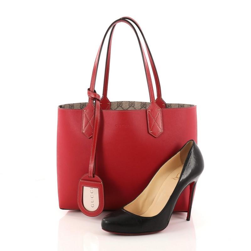 This authentic Gucci Reversible Tote GG Print Leather Small is perfect for everyday casual looks. Crafted in red leather and taupe GG print leather on its reverse side with contrast beige stitching, this simple shopper-style tote features tall slim