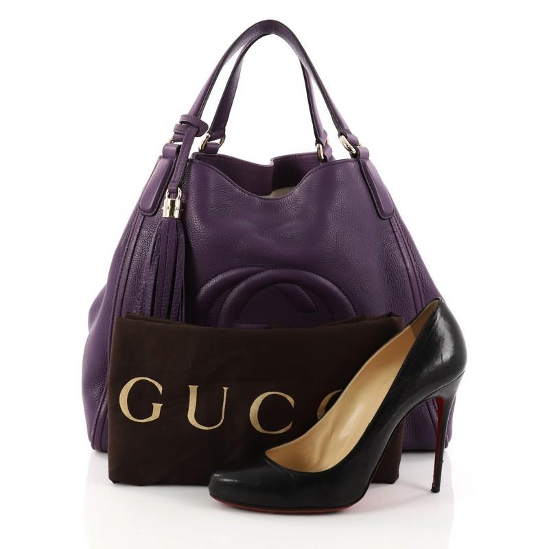This authentic Gucci Soho Shoulder Bag Leather Medium is simple yet stylish in design. Crafted in purple leather, this hobo features dual-flat leather handles, fringe tassel, protective base studs, signature interlocking Gucci logo stitched in front