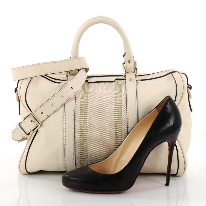 This authentic Gucci Vintage Web Boston Bag Leather Medium is a recognizable classic. Crafted from white leather with signature web stripes, this bag features dual-rolled handles, protective base studs, and gold-tone hardware accents. The top zipper