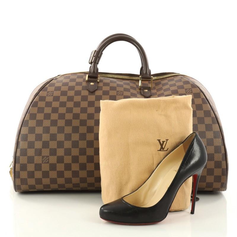 This authentic Louis Vuitton Ribera Handbag Damier GM is a luxe weekender accessory perfect for traveling. Crafted from Louis Vuitton's signature damier ebene coated canvas, this structured dome satchel features dual-rolled dark brown leather
