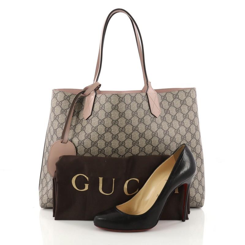 This authentic Gucci Reversible Tote GG Print Leather Medium is perfect for everyday casual looks. Crafted in taupe GG print leather and light mauve leather on its reverse side, this simple shopper-style tote features tall slim handles and subtle
