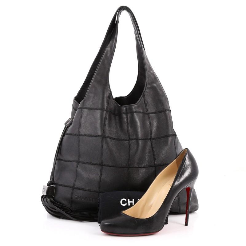 This authentic Chanel Square Stitch Tassel Hobo Quilted Leather Large showcases a classic and timeless design perfect for the modern woman. Crafted from supple black leather, this casual hobo features square stitch detailing, subtle Chanel imprinted