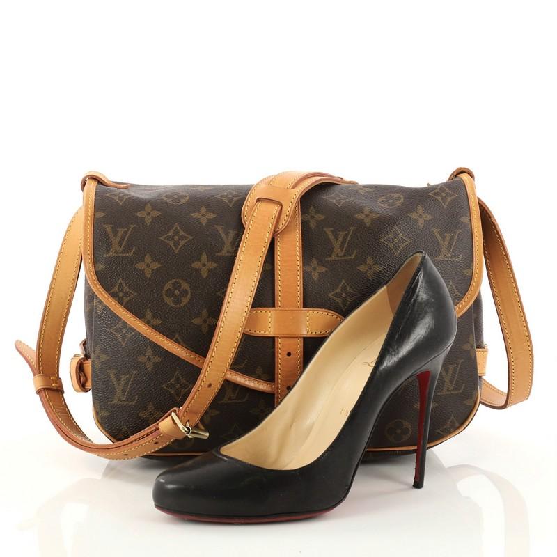 This authentic Louis Vuitton Saumur Handbag Monogram Canvas PM showcases the brand's reinterpretation of the classic saddle bag. Crafted in Louis Vuitton's brown monogram coated canvas, this bag features long adjustable shoulder strap, double saddle