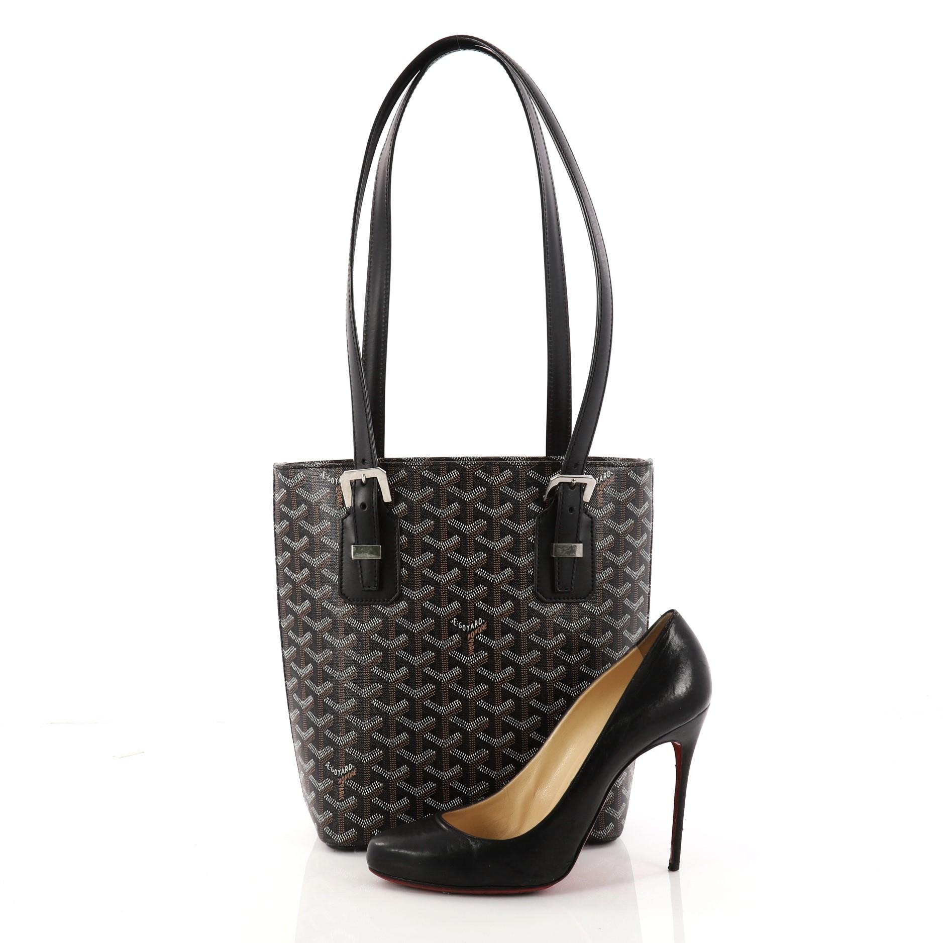 This authentic Goyard Marie Galante Handbag Coated Canvas PM exhibit a timeless elegance perfect for the stylish fashionista. Crafted from black coated canvas, this classic and contemporary bag features dual flat leather shoulder straps with buckle