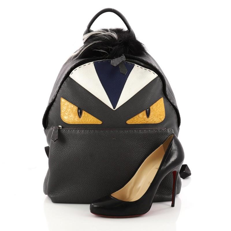 This authentic Fendi Selleria Monster Backpack Leather and Fur Medium balances a luxurious, playful style made for on-the-go fashionistas. Crafted from gray leather, this backpack features eye-catching monster eye design, a flat top handle, fur