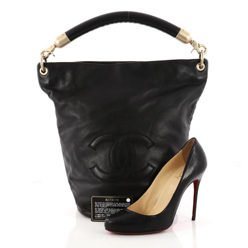 This authentic Chanel Vintage CC Handle Bucket Bag Leather Large showcases an elegant and timeless design made for Chanel lovers. Crafted in black leather, this bag features looping leather handle, CC stitched logo at front, round base and matte