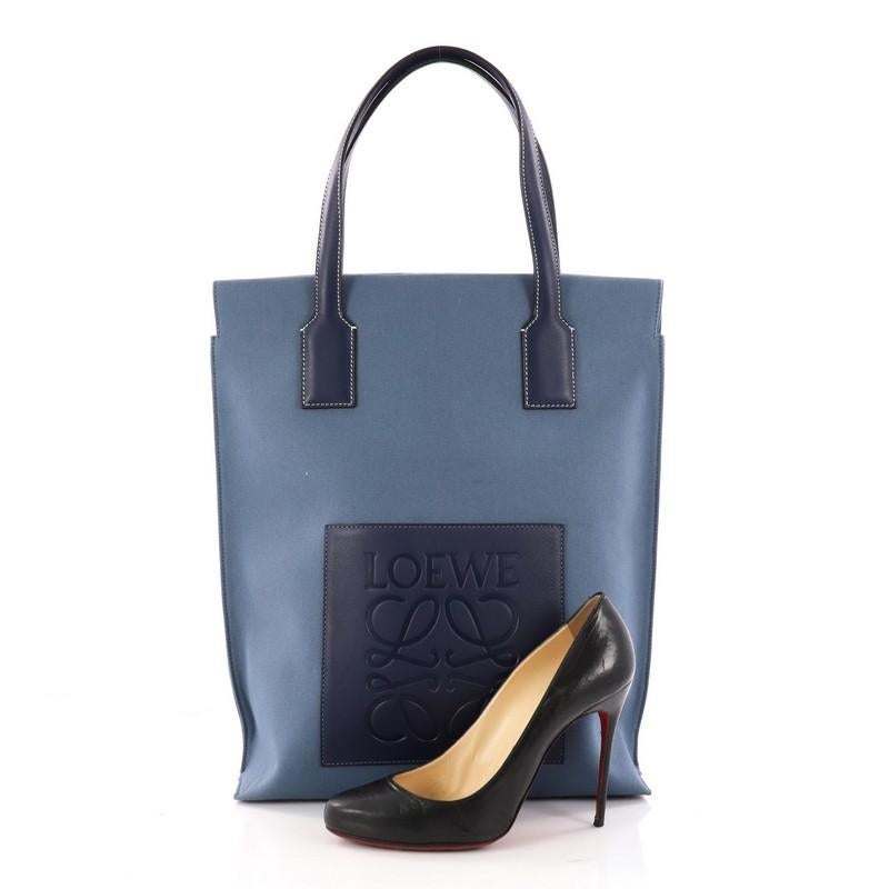 This authentic Loewe Shopper Tote Canvas North South is simply a must-have for your wardrobe. Crafted in blue canvas, this tote features dual top leather handles with contrast stitching, leather pad with Loewe logo and silver-tone hardware accents.