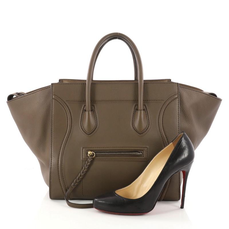 This authentic Celine Phantom Handbag Grainy Leather Medium is one of the most sought-after bags beloved by fashionistas. Crafted from taupe grainy leather, this minimalist tote features dual-rolled handles, an exterior front pocket, protective base