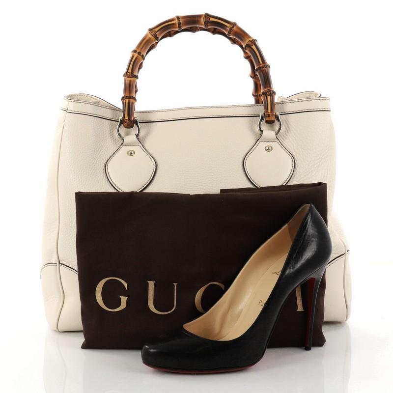This authentic Gucci Diana Bamboo Top Handle Tote Leather Medium is a chic tote ideal for your everyday wear. Crafted from beige leather, this tote features dual bamboo top handles, gusseted sides, protective base studs, and gold-tone hardware