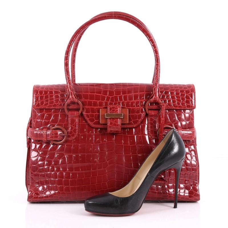 This authentic Salvatore Ferragamo Belt Flap Weekender Bag Alligator Medium displays a ladylike sophistication perfect for the chic fashionista. Crafted from genuine red alligator skin, this stylish bag features dual-rolled shoulder straps, front