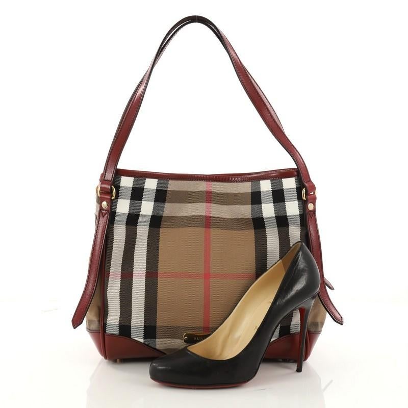 This authentic Burberry Canterbury Tote House Check Canvas Small is perfect for casual wear. Crafted from the brand's house check canvas, this tote features dual tall adjustable handles, burgundy leather trims, stamped gold Burberry name, protective