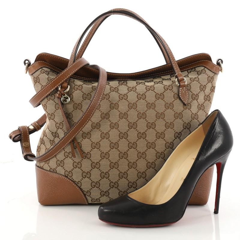This authentic Gucci Bree Convertible Top Handle Bag GG Canvas with Leather Medium is an elegant bag perfect for everyday casual looks. Crafted in brown GG canvas with light brown leather trims, this tote features dual flat handles, leather string