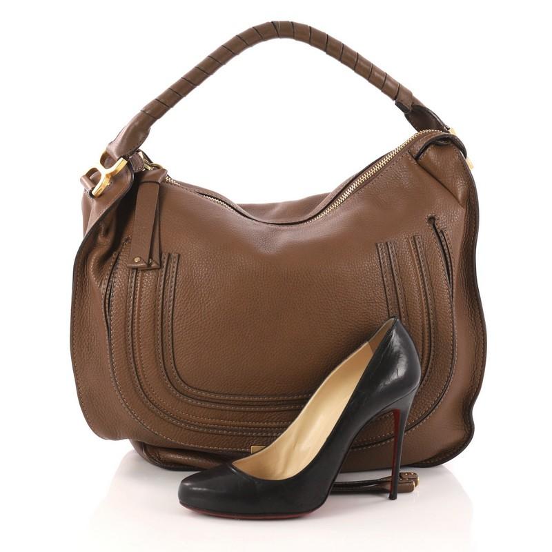 This authentic Chloe Marcie Hobo Leather Large showcases the brand's popular horseshoe design in a classic hobo design. Constructed from beautiful brown leather, this functional yet stylish hobo bag features a slouchy, easy-to-carry silhouette,