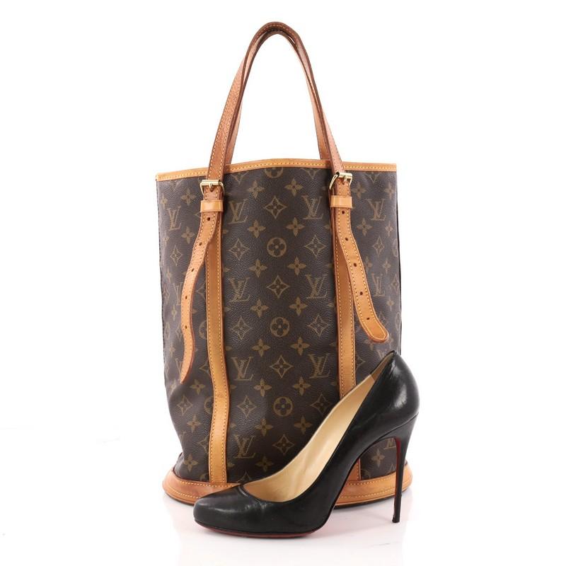 This authentic Louis Vuitton Bucket Bag Monogram Canvas GM is the ideal bag to hold all your daily essentials. Crafted from brown monogram coated canvas, this elongated bucket bag features dual flat leather straps with buckle details, a sturdy base,