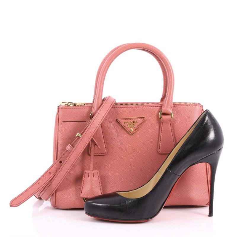 This authentic Prada Double Zip Lux Tote Saffiano Leather Mini is the perfect bag to complete any outfit. Crafted from pink saffiano leather, this boxy tote features side snap buttons, raised Prada logo, dual-rolled leather handles and gold-tone