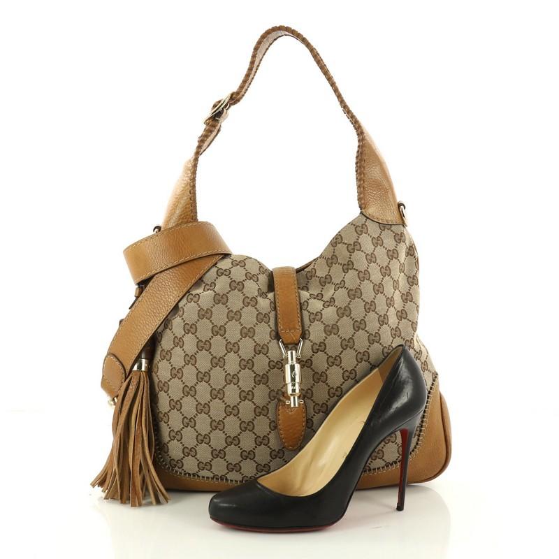 This authentic Gucci New Jackie Handbag GG Canvas Medium is a must-have luxurious everyday hobo fit for the modern woman. Crafted from brown GG canvas, this re-imagined bag features an adjustable shoulder strap, whipstitched edges, side leather