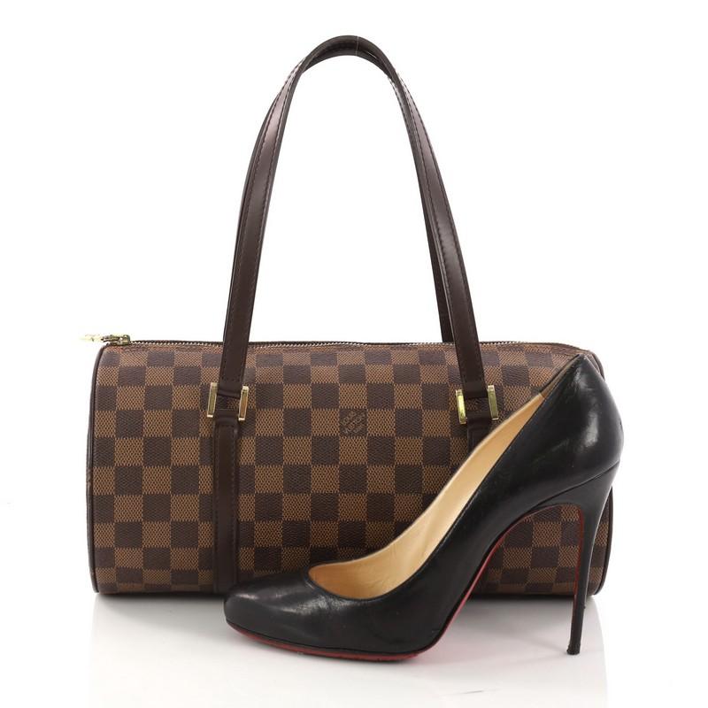 This authentic Louis Vuitton Papillon Handbag Damier 30 is one of Louis Vuitton's iconic bags with its unique round shape that complements both dressy and casual looks. Crafted with damier ebene coated canvas and dark brown leather trims, this
