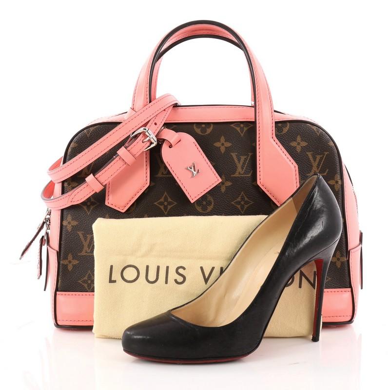 This authentic Louis Vuitton Dora Handbag Monogram Canvas and Calf Leather PM is inspired by Gaston Vuitton's iconic squire travel bag. Crafted from brown monogram coated canvas and pink calf leather, this luxurious structured satchel features dual