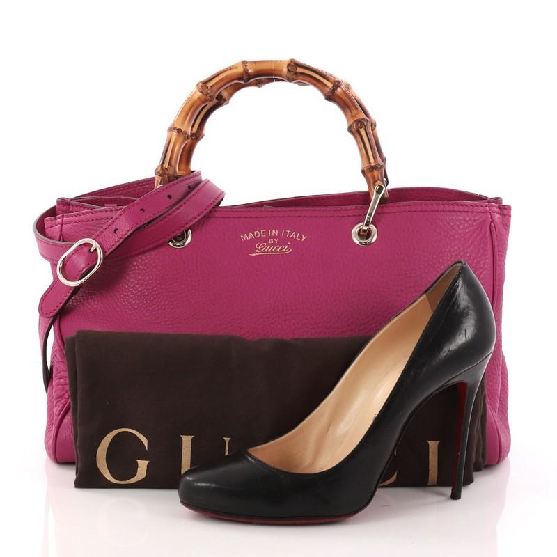 This authentic Gucci Bamboo Shopper Tote Leather Medium is a classic must-have. Crafted from magenta leather, this simple yet stylish tote features Gucci's signature sturdy bamboo handles, protective base studs, stamped logo at the front, and bamboo