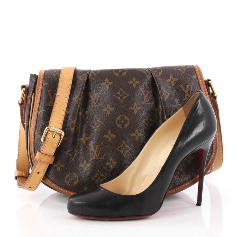 This authentic Louis Vuitton Menilmontant Handbag Monogram Canvas PM is perfect for on-the-go fashionistas. Crafted in iconic brown monogram coated canvas with vachetta leather trims, this luxurious satchel features a full frontal flap with pleated