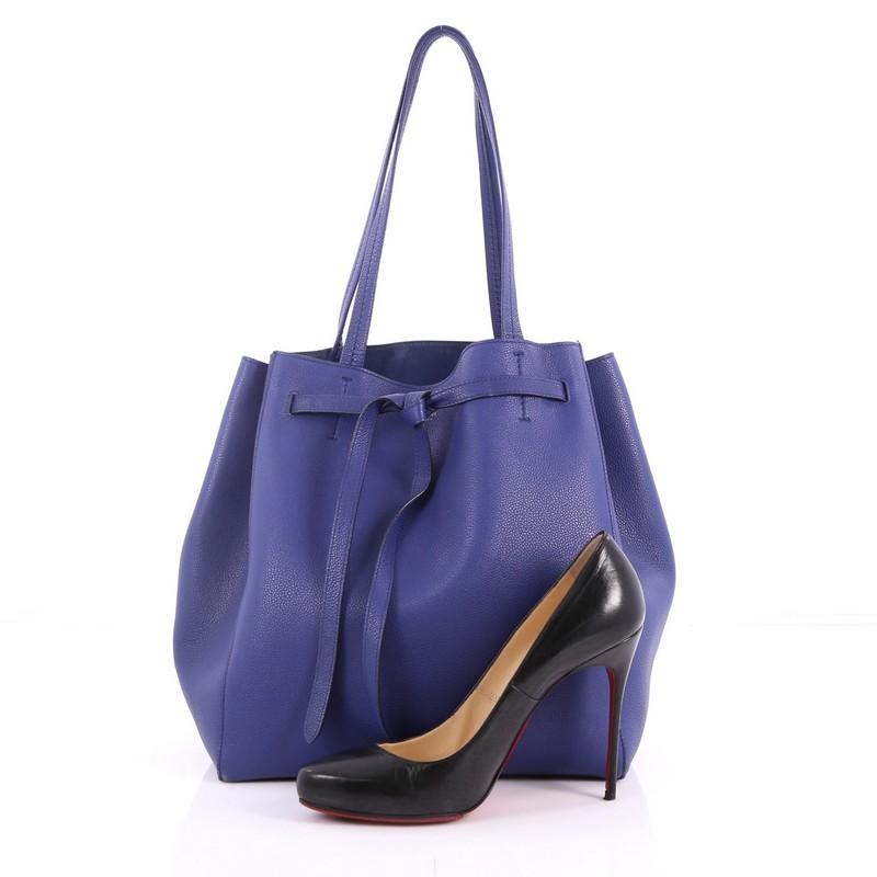 This authentic Celine Phantom Tie Cabas Tote Leather Small is a fashionista's go-to stylish essential. Crafted from blue leather, this minimalist city tote features dual flat tall handles, stamped Celine logo, and gold-tone hardware accents. Its