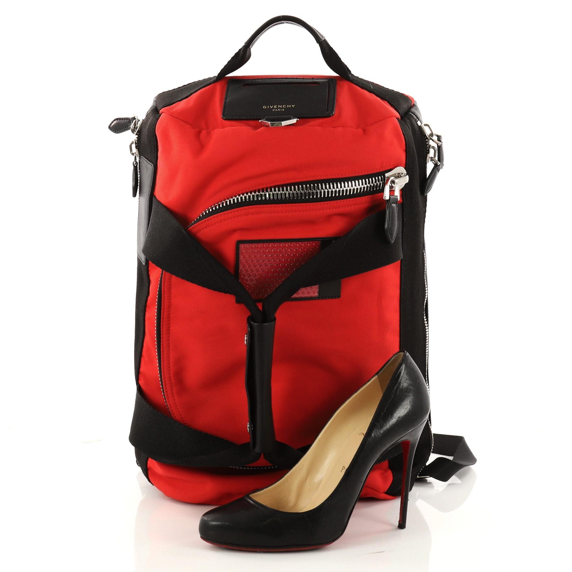 This authentic Givenchy Convertible Duffle Backpack Nylon and Leather is the ideal bag for everyday utility. Crafted in red nylon and black leather, this cutting-edge backpack features top handles with snap keeper, carrying handle, adjustable back