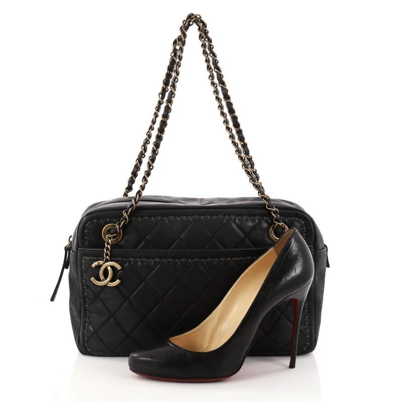 This authentic Chanel Whipstitch Camera Case Bag Quilted Iridescent Calfskin Large is a stylish and unique bag. Crafted in black quilted iridescent calfskin, this chic bag features dual woven-in leather chain straps, exterior front and back pockets,