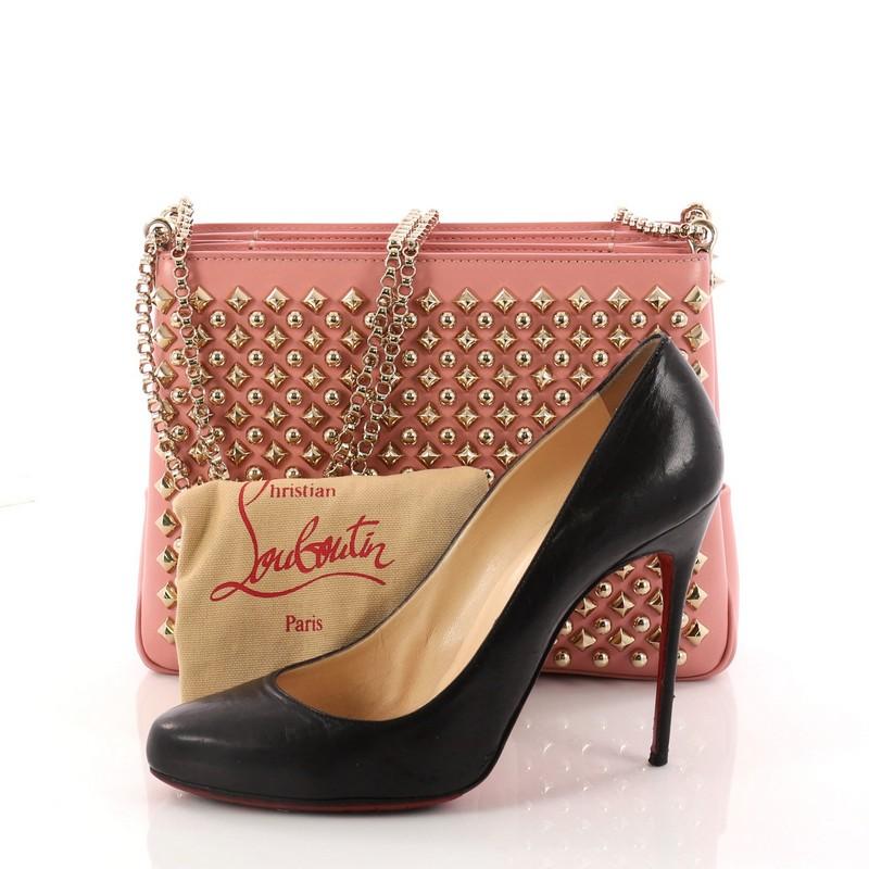 This authentic Christian Louboutin Triloubi Chain Bag Spiked Leather Small balances an edgy-chic design with feminine flair perfect for nights out. Crafted in pink leather, this day-to-night chain bag features Louboutin's signature red-sole design