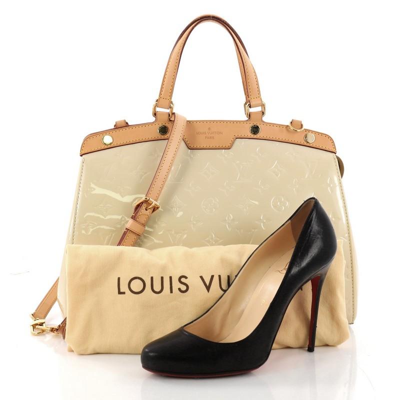 This authentic Louis Vuitton Brea Handbag Monogram Vernis MM is a staple for an everyday casual look. Crafted in beige monogram vernis leather with cowhide leather trims, this structured yet feminine tote features dual flat handles, protective base