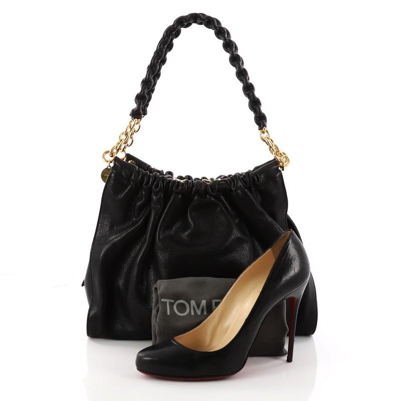 This authentic Tom Ford Carine Shoulder Bag Leather Medium is every fashionista’s dream. Constructed from black leather with a ruched pleated design, this sleek yet feminine bag features dual wrapped leather chain shoulder straps, two exterior